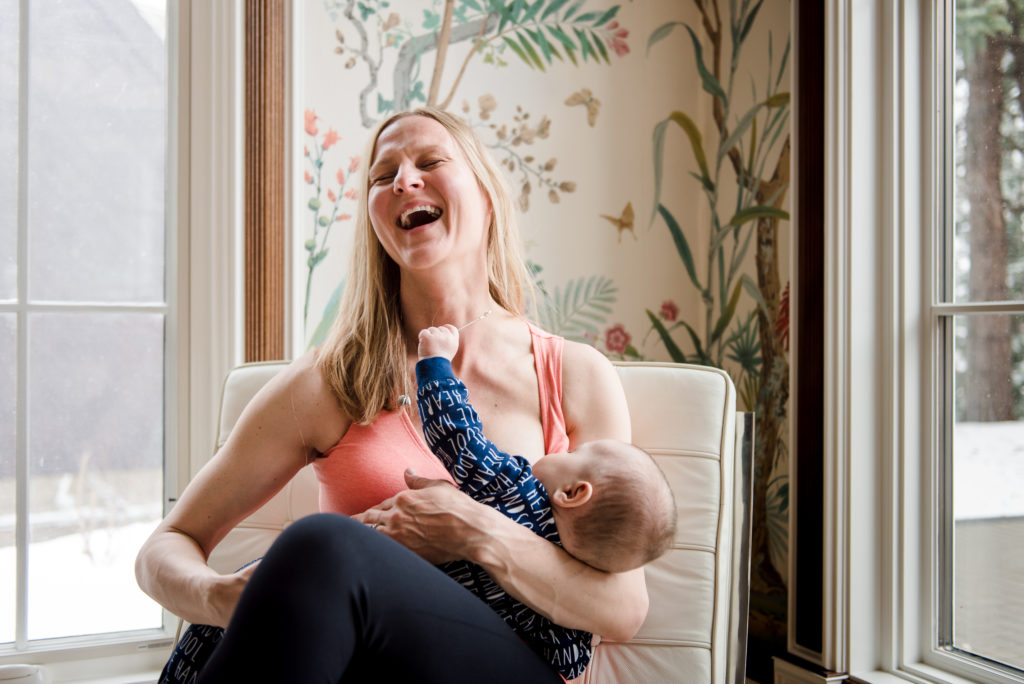 A nursing mama wears a versatile peach coloured tank from Edmonton Maternity Store, Yo Mama Maternity. 
