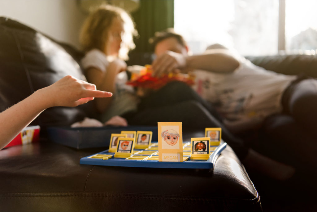 A family plays Guess Who in their Sherwood Park home. How to take better photos at home. 