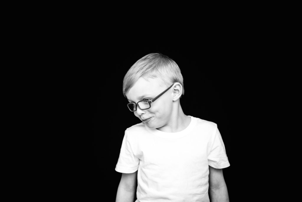 A black and white portrait of a boy wearing a white shirt during a studio school photo in Sherwood Park