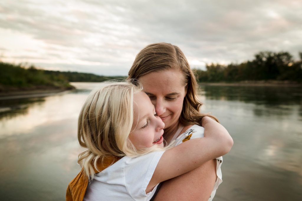 A mom and daughter hug down by the river in Edmonton Alberta