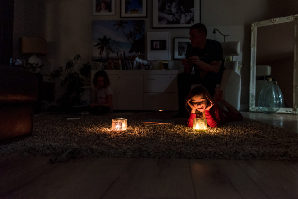 kids read books by candle light as part of a holiday activity advent calendar. 

